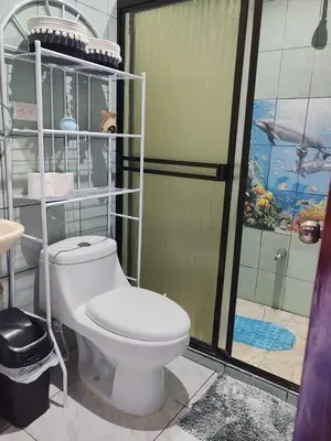 a bathroom with a white toilet and a shower at YAIZA HOUSE Jaco in Jacó