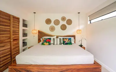 a bedroom with a large bed with a wooden headboard at 3BR Peaceful Retreat Walking Distance to Beach in Tamarindo