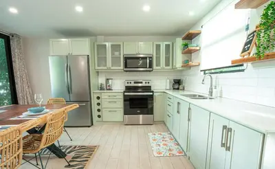 a kitchen with white cabinets and a table and a sink at 3BR Peaceful Retreat Walking Distance to Beach in Tamarindo