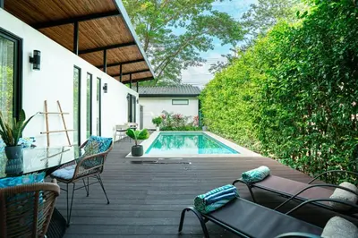a backyard with a swimming pool and a wooden deck at 3BR Peaceful Retreat Walking Distance to Beach in Tamarindo