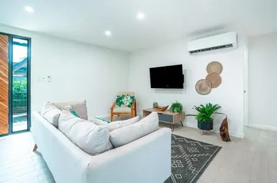 a living room with a white couch and a tv at 3BR Peaceful Retreat Walking Distance to Beach in Tamarindo