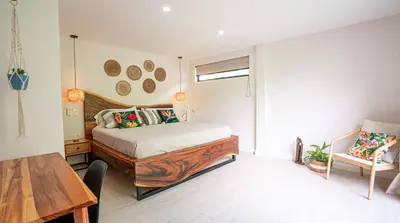 a bedroom with a bed and a wooden table at 3BR Peaceful Retreat Walking Distance to Beach in Tamarindo