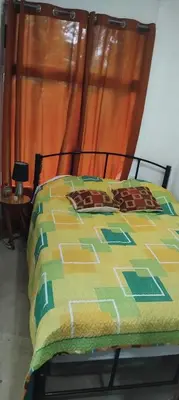 a bed with a colorful quilt on top of it at La casita de Antonio en Sarapiqui in Llano Grande