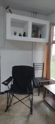 a black chair in a room with a table at La casita de Antonio en Sarapiqui in Llano Grande