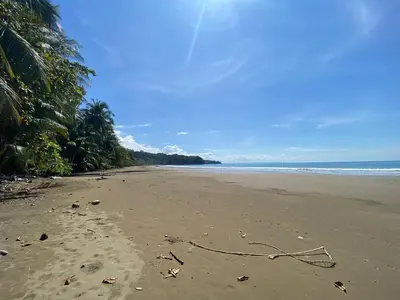 a sandy beach with a rope laying on the sand at Casa Ballena with Beach Access and Private Pool in Uvita