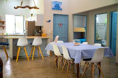 a kitchen with a table with white chairs and blue cabinets at Casa Ballena with Beach Access and Private Pool in Uvita