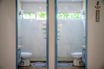 a bathroom with a shower and two toilets at Casa Ballena with Beach Access and Private Pool in Uvita