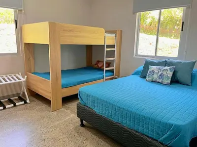 a bedroom with two bunk beds and a crib at Casa Ballena with Beach Access and Private Pool in Uvita