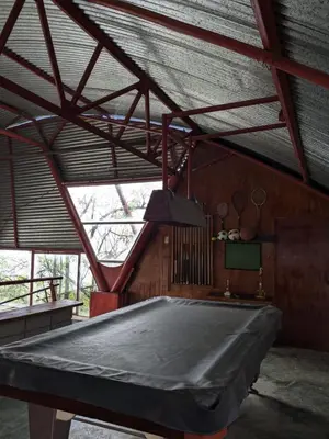 a pool table in a room with a roof at Alojamiento el Mirador in Tapantí