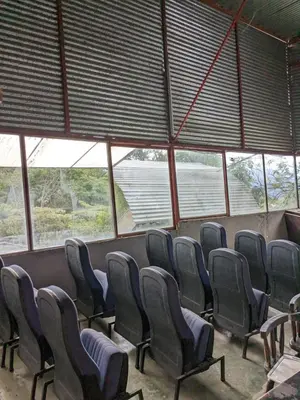 a row of chairs in a room with windows at Alojamiento el Mirador in Tapantí