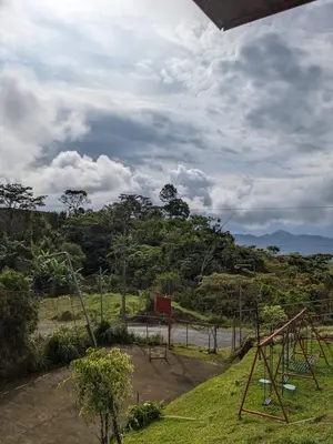 an empty park with a swing set in the grass at Alojamiento el Mirador in Tapantí