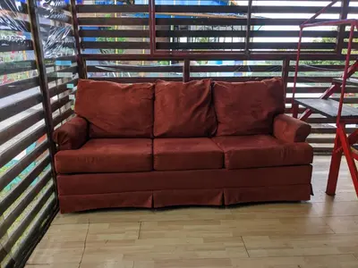 a brown couch sitting in the middle of a room at Alojamiento el Mirador in Tapantí