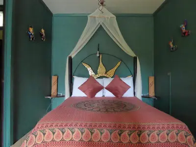 a bedroom with a bed with a red comforter at Lucky Bug Bed And Breakfast in Nuevo Arenal