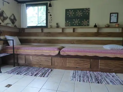 a room with two wooden benches in a room at Lucky Bug Bed And Breakfast in Nuevo Arenal