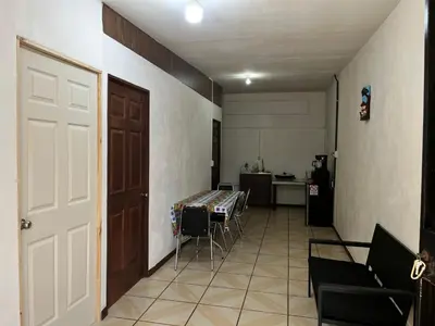 a hallway with a door and a table and a kitchen at Este no 3 habitaciones in Siquirres