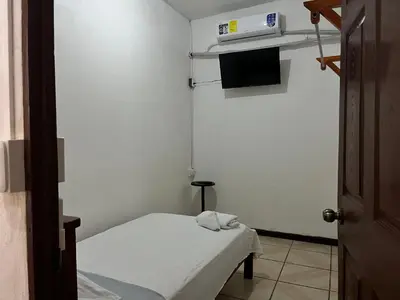 a small room with a bed and a tv at Este no 3 habitaciones in Siquirres