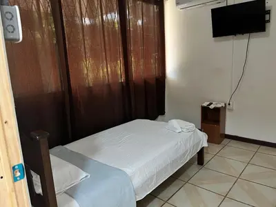 a small bedroom with a bed and a flat screen tv at Este no 3 habitaciones in Siquirres
