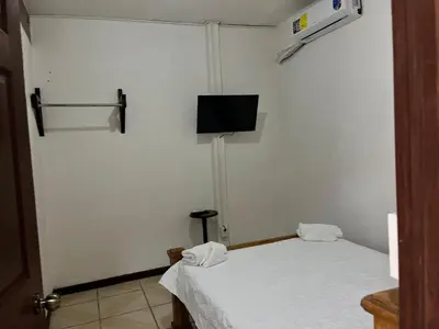 a room with a bed and a tv on the wall at Este no 3 habitaciones in Siquirres