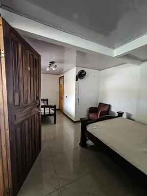 a room with a bed and a chair and a door at Liahs tortuguero in Tortuguero