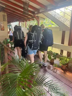 a group of people walking down a hallway with backpacks at Liahs tortuguero in Tortuguero
