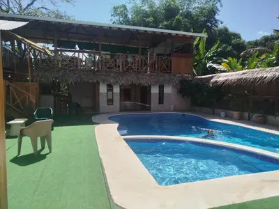 a swimming pool in front of a house at Liahs tortuguero in Tortuguero