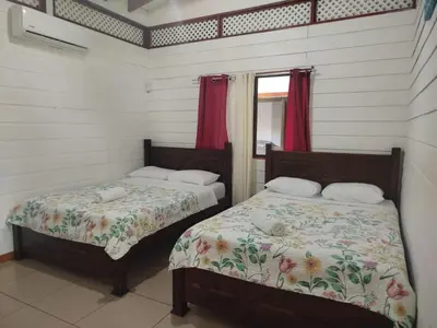 a bedroom with two beds and a window at Liahs tortuguero in Tortuguero