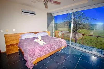 a bedroom with a bed and a large window at Catalina World Class Viewslocationservice! in Sámara