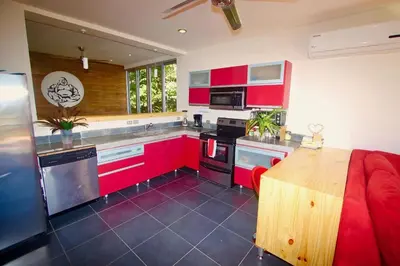 a kitchen with red cabinets and a wooden table at Catalina World Class Viewslocationservice! in Sámara