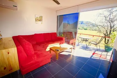a living room with a red couch and a table at Catalina World Class Viewslocationservice! in Sámara