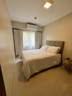 a bedroom with a large white bed with a window at Refugio Caribeño in Puerto Limón