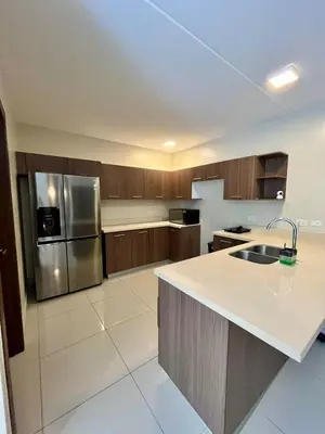 a kitchen with wooden cabinets and a stainless steel refrigerator at Refugio Caribeño in Puerto Limón
