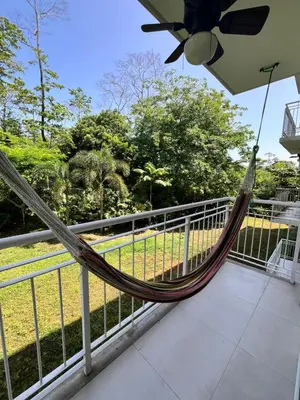 a hammock on the balcony of a house at Refugio Caribeño in Puerto Limón