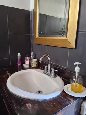 a bathroom counter with a sink and a mirror at Apartamento Céntrico con Vista in Heredia