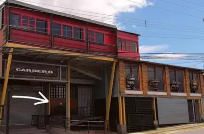a red building with a white arrow in front of it at Apartamento Céntrico con Vista in Heredia