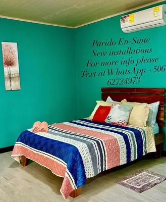 a bedroom with a bed with a sign on the wall at Paraiso En-suite #3 in Parrita