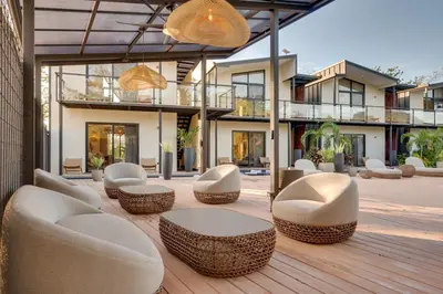 a patio with chairs and tables and a building at The Bungalows Flamingo - 10 Unit Boutique Hotel in Playa Flamingo