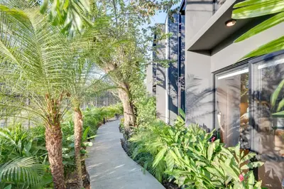 a garden with palm trees and a walkway at The Bungalows Flamingo - 10 Unit Boutique Hotel in Playa Flamingo