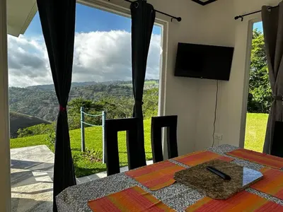a room with a table and a tv and a window at Casa grano de oro in Turín