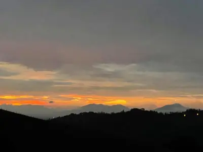 a sunset over a mountain range with the sun setting at Casa grano de oro in Turín
