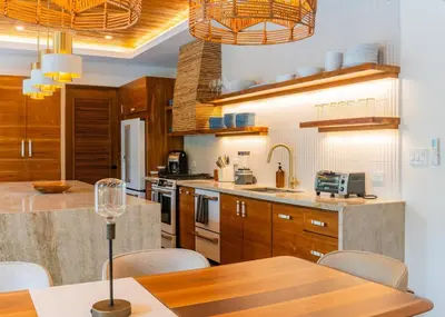 a kitchen with wooden cabinets and a table with chairs at Casa Rocky Point in Nosara
