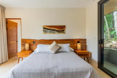 a bedroom with a bed and a glass door at Casa Rocky Point in Nosara