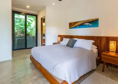 a bedroom with a large bed and a window at Casa Rocky Point in Nosara