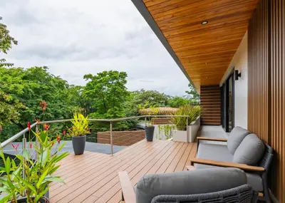 a wooden deck with chairs and tables on a house at Casa Rocky Point in Nosara