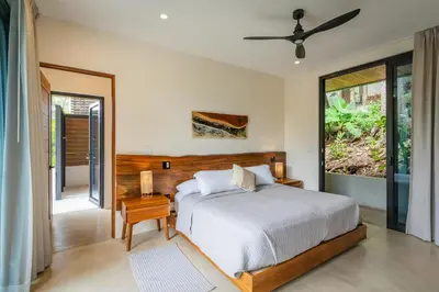 a bedroom with a bed and a large window at Casa Rocky Point in Nosara