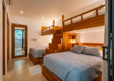 a bedroom with two bunk beds and a staircase at Casa Rocky Point in Nosara