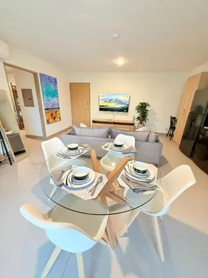 a living room with a glass table and chairs at Viva Jaco Unit 0605 in Jacó