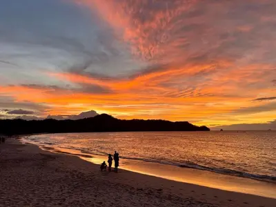 two people and two dogs on the beach at sunset at Welcome to paradise!Reserva Conchal, Solaris, C-1A in Playa Conchal