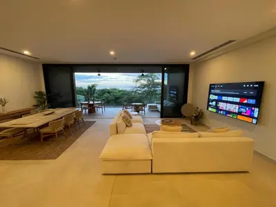 a living room with a couch and a flat screen tv at Welcome to paradise!Reserva Conchal, Solaris, C-1A in Playa Conchal
