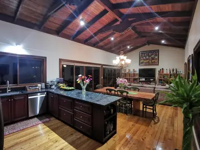a kitchen and living room with a table and a couch at Mountain View Near SJO Airport Fast WiFi in Alajuela City