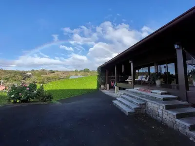 a building with steps next to a green lawn at Mountain View Near SJO Airport Fast WiFi in Alajuela City